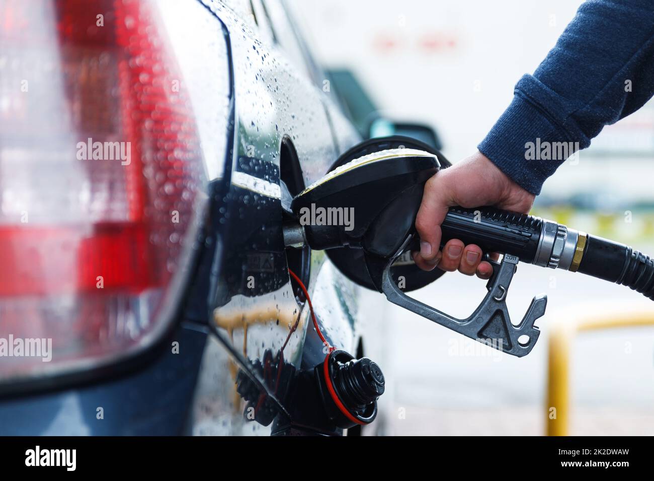 Der Mann füllt den Tank seines Autos auf der Tankstelle Stockfoto
