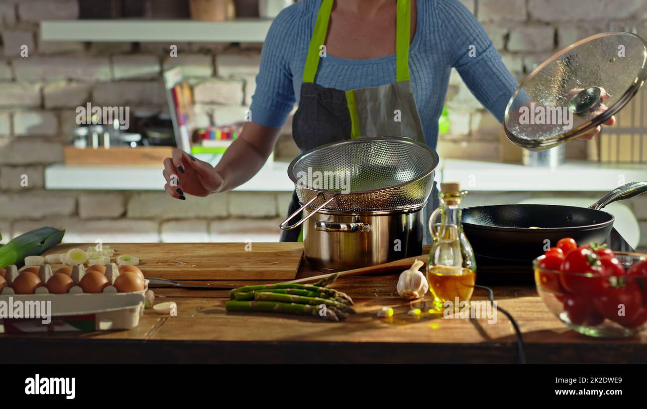 Eine gesichtslose Frau, die in der Küche kocht Stockfoto