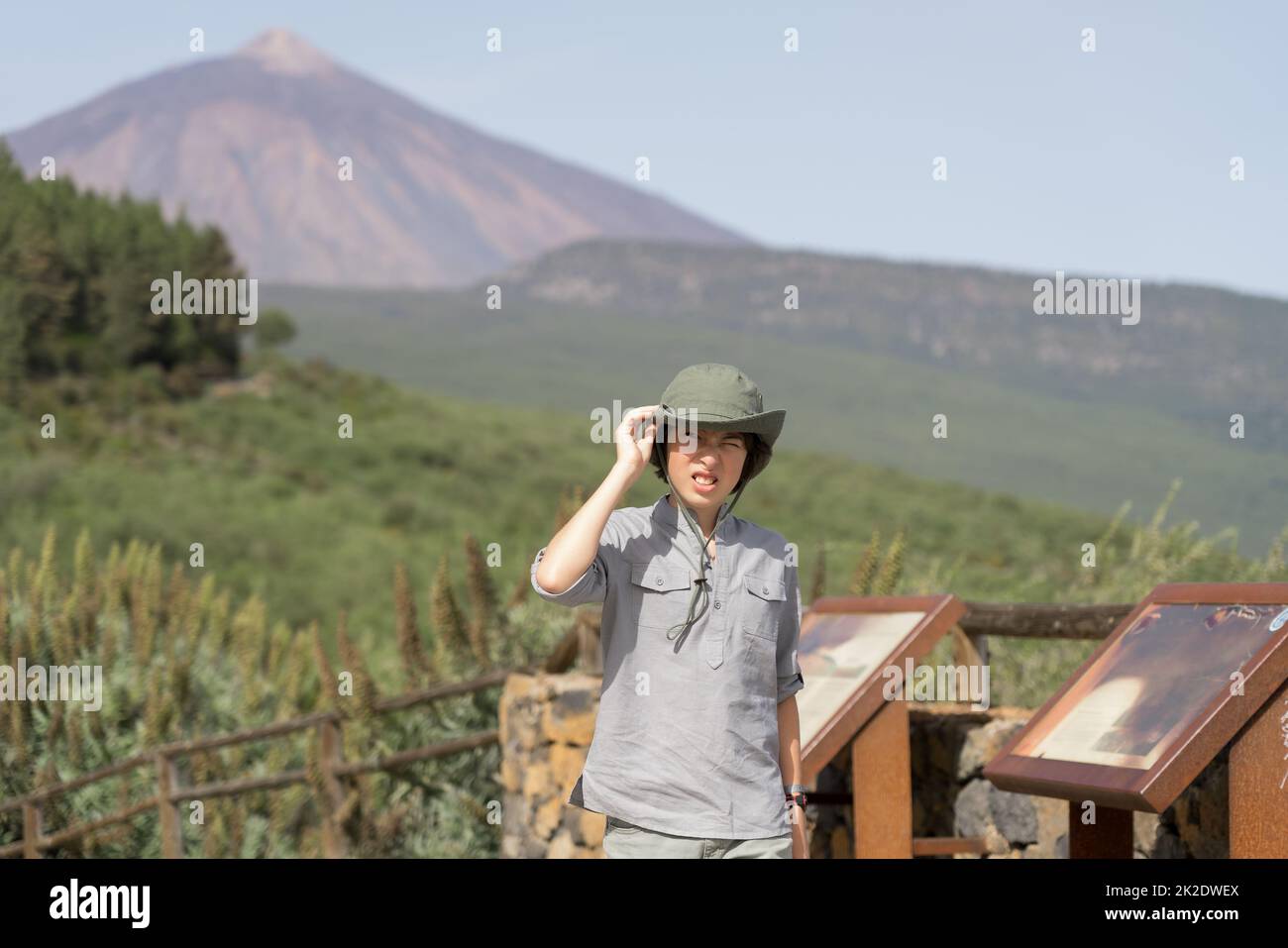 Ein Teenager steht auf einer Aussichtsplattform hoch in den Bergen. Im Hintergrund ist der Vulkan Teide zu sehen. Teneriffa. Kanarische Inseln. Spanien. Stockfoto