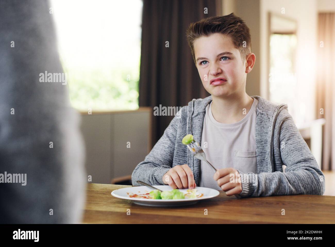 Ich gehe lieber hungrig ins Bett. Aufnahme eines Jungen, der sich weigert, seine brüsseler Sprossen zu Hause zu essen. Stockfoto
