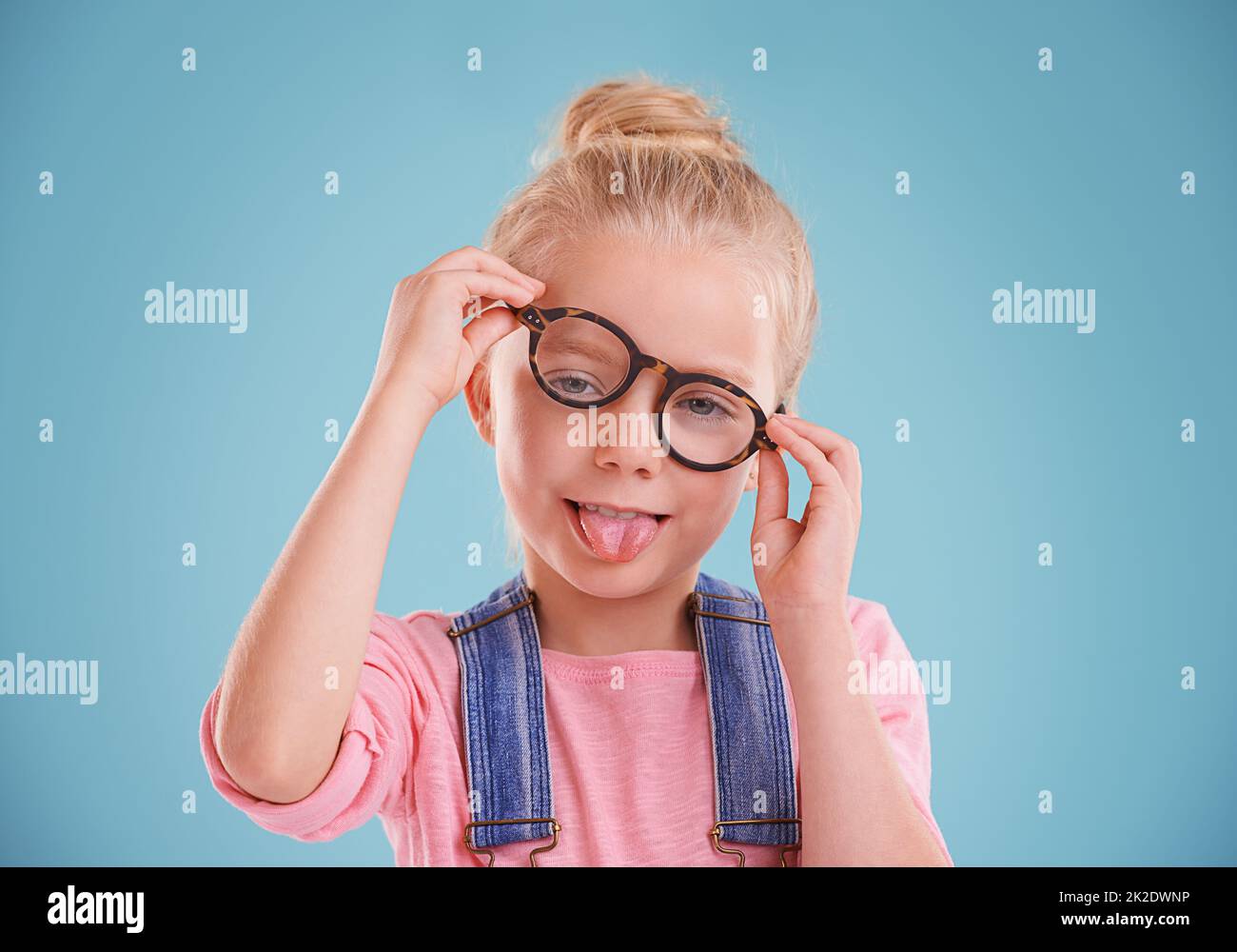 Diese Gläser sind so lustig. Studioaufnahme eines kleinen Mädchens mit einer Hipster-Brille auf blauem Hintergrund. Stockfoto