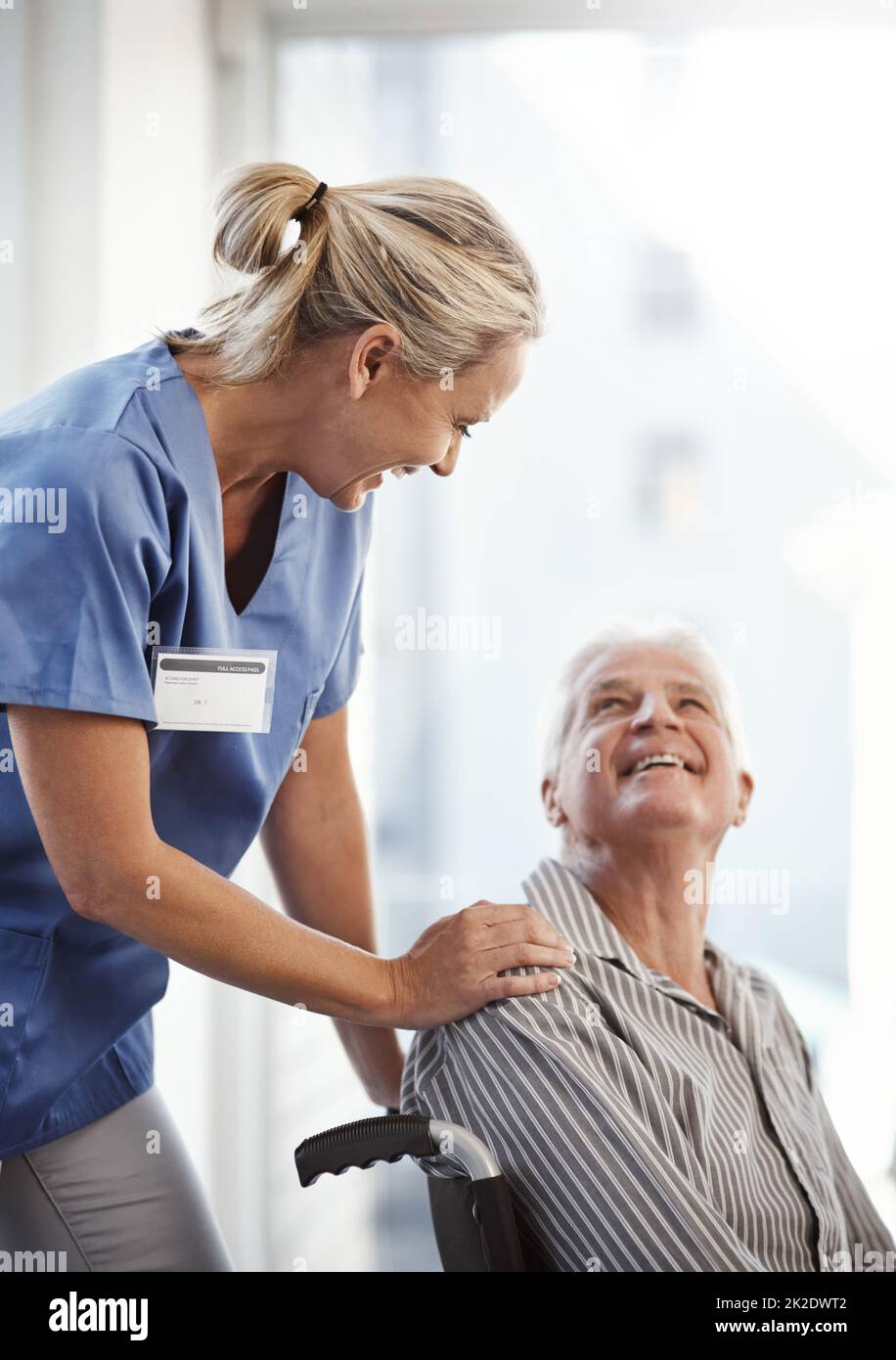 Wohin, Herr. Ausgeschnittene Aufnahme einer reifen Krankenschwester und ihres älteren Patienten mit Rollstuhl im Krankenhaus. Stockfoto