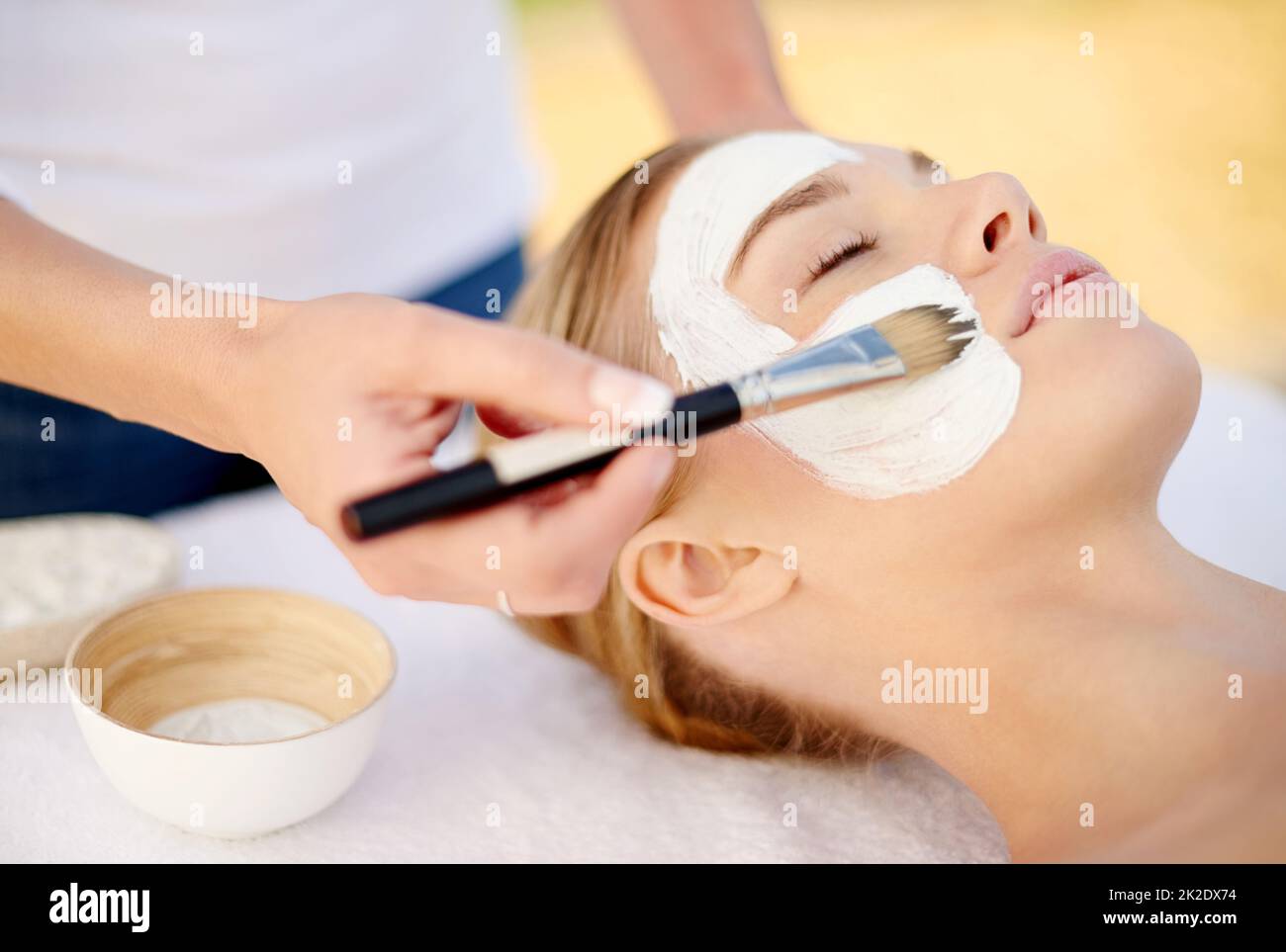 Der Haut die besondere Behandlung zu geben. Aufnahme einer jungen Frau, die in einem Spa eine Gesichtsbehandlung bekommt. Stockfoto