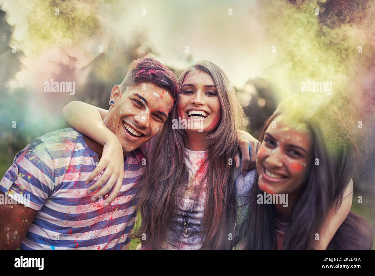 Regenbogen-Verfolger. Aufnahme von glücklichen Freunden, die Spaß mit Pulverfarbe haben. Stockfoto