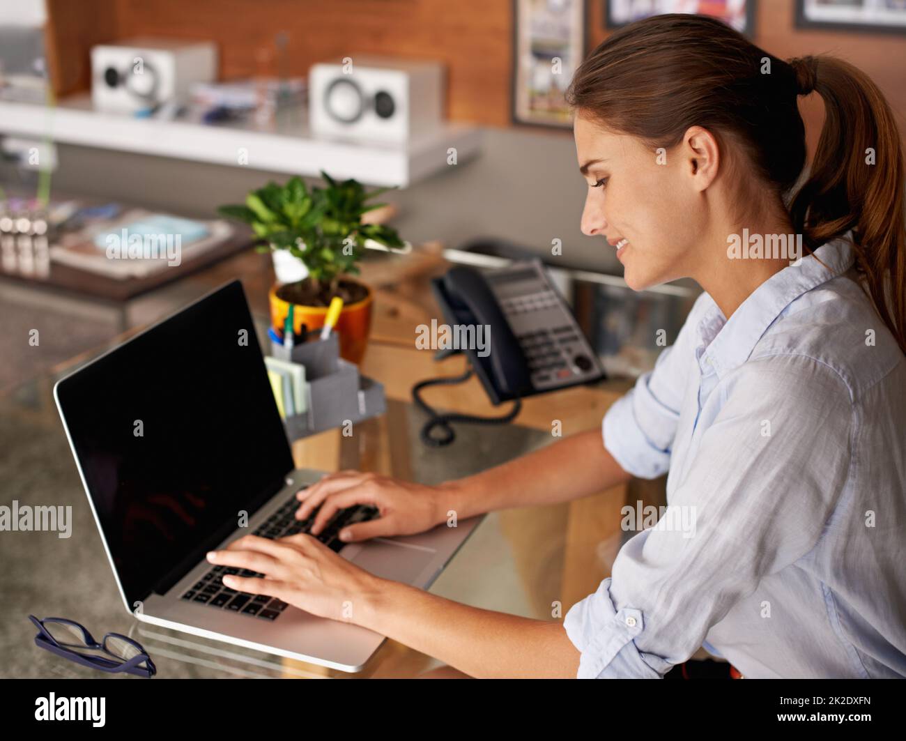 Arbeit nach Geschäftsschluss erledigen. Eine attraktive junge Frau, die von ihrem Heimbüro aus arbeitet. Stockfoto