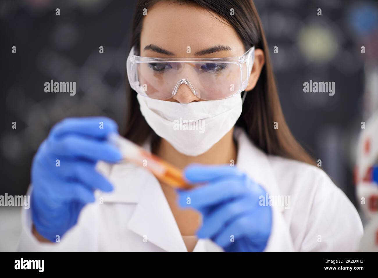 Schließlich ist die Verbindung vollständig. Aufnahme einer Wissenschaftlerin, die eine Probe in einem Reagenzglas beobachtet. Stockfoto