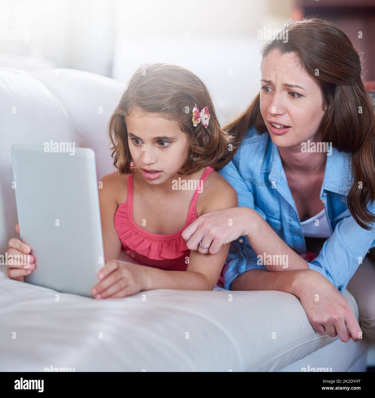 Vergessen Sie nicht, sicher zu suchen. Zugeschnittene Aufnahme einer Mutter und ihrer Tochter, die zu Hause Wireless-Technologie verwendet. Stockfoto