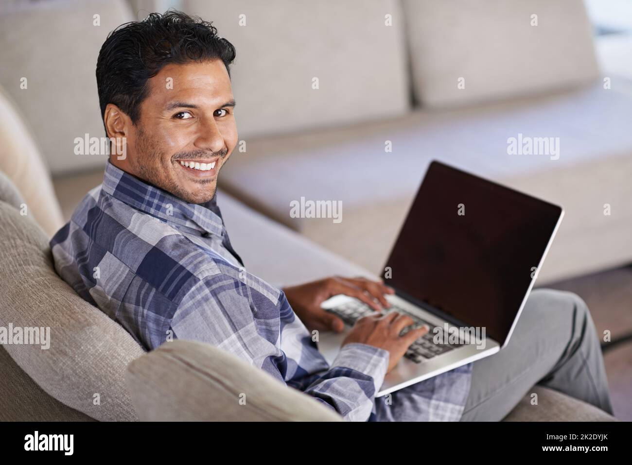 Auf meinem Blog arbeiten. Ein junger Mann, der von zu Hause aus an seinem Laptop arbeitet. Stockfoto