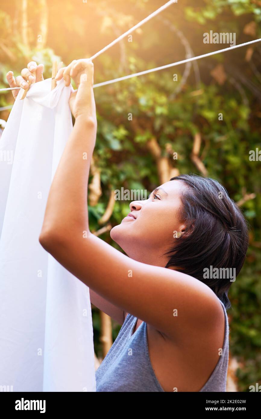 Diese Wäsche trocknet im Handumdrehen. Aufnahme einer jungen Frau, die ihre Wäsche an der Wäscheleine aufgehängt hat. Stockfoto