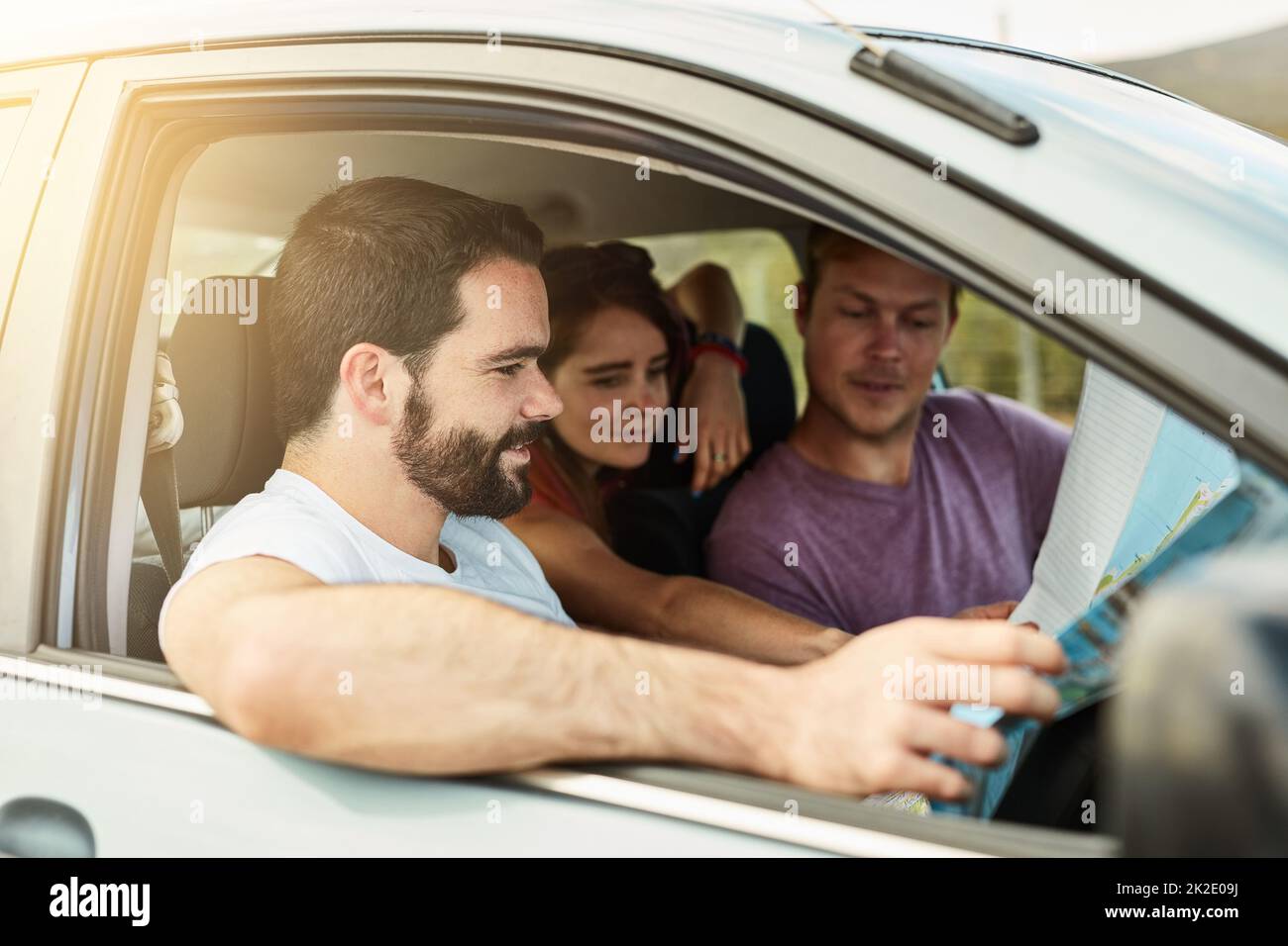 Alle Systeme gehen. Aufnahme einer Gruppe junger Freunde, die sich bereit machen, mit ihrem Fahrzeug zu ihrem Ziel zu fahren, während sie sich eine Karte ansehen. Stockfoto