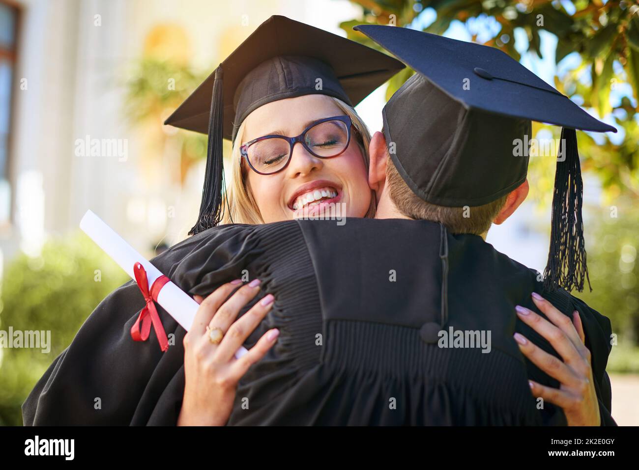 Wir feiern unsere große Leistung. Aufnahme eines jungen Paares, das sich am Abschlusstag umarmt. Stockfoto