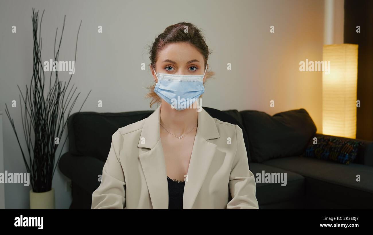 Porträt einer hübschen Frau mit Maske und Blick in die Kamera. Blaue Augen und blondes Haar. Stockfoto