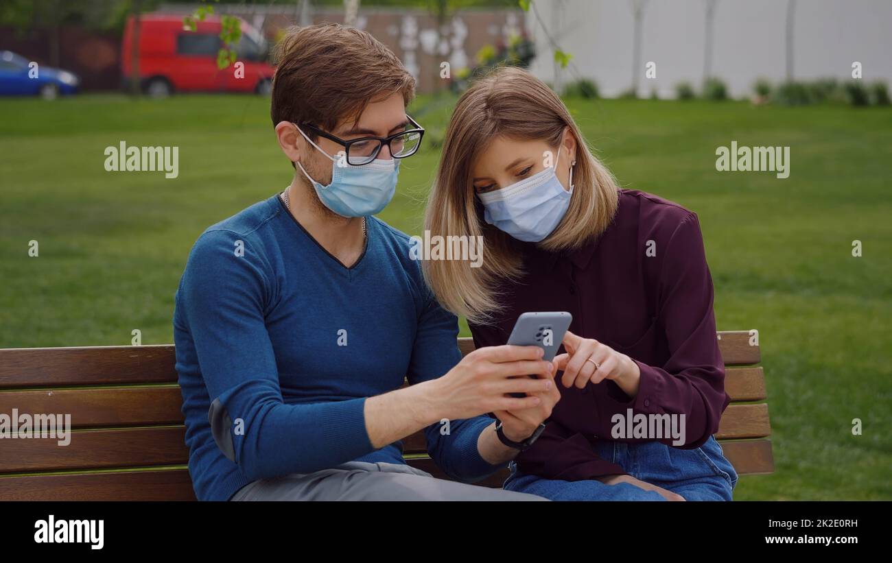 Zwei süße Leute schauen am Telefon genau hin und finden es in den Nachrichten von Covid-19 heraus Stockfoto