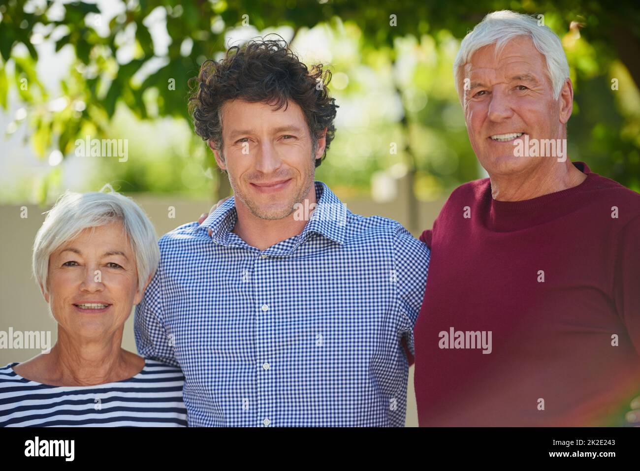 Wir hätten nicht stolzer sein können. Beschnittenes Porträt eines älteren Paares, das mit ihrem Sohn draußen steht. Stockfoto