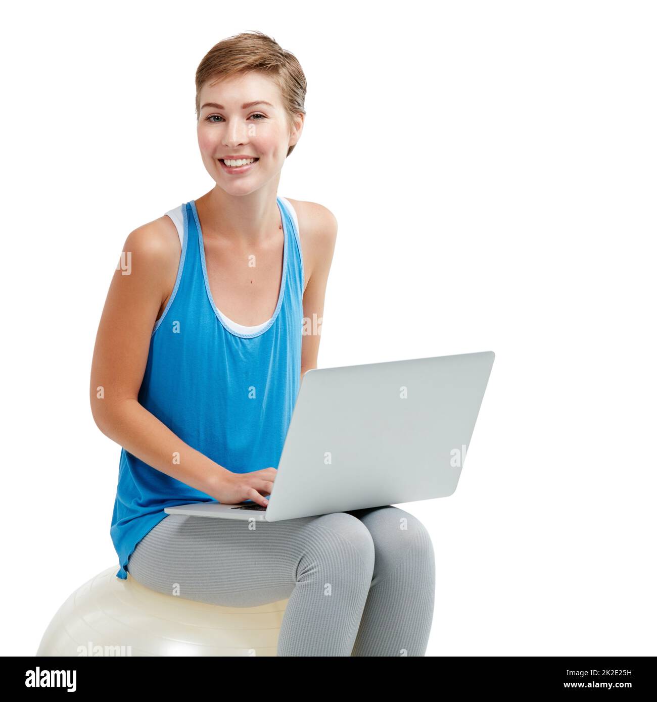 Warum unter Rückenschmerzen leiden, surfen Sie bequem. Aufnahme einer jungen Frau, die einen Laptop benutzt, während sie auf einem Übungsball sitzt. Stockfoto