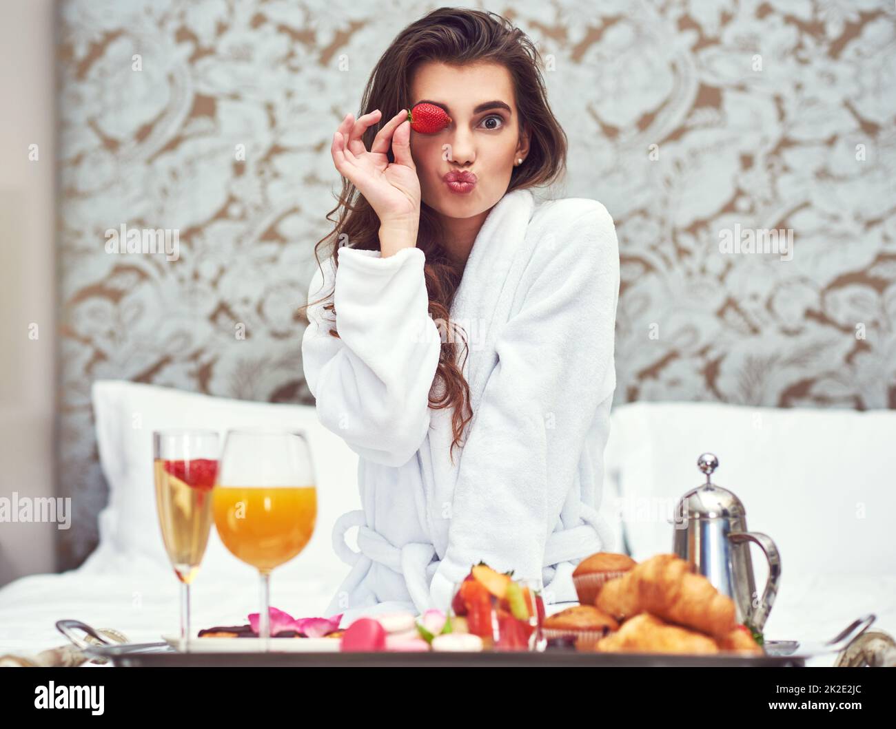 Genießen Sie ein Frühstück, das Ihnen einen Schönheitsschub verleiht. Aufnahme einer attraktiven jungen Frau, die in ihrem Zimmer ein luxuriöses Frühstück genießt. Stockfoto
