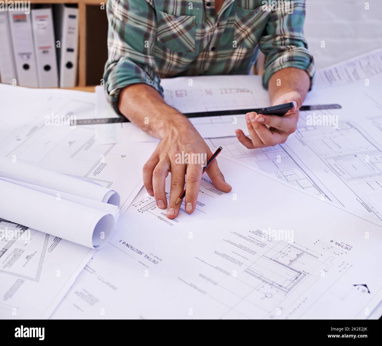 Design für Profis. Ausgeschnittene Aufnahme eines männlichen Architekten, der an einem Tisch an Blaupausen arbeitet. Stockfoto