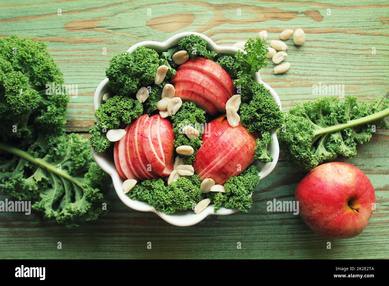 Salat mit Grünkohl Kopfsalat, Äpfeln, Erdnüsse. Ansicht von oben Stockfoto