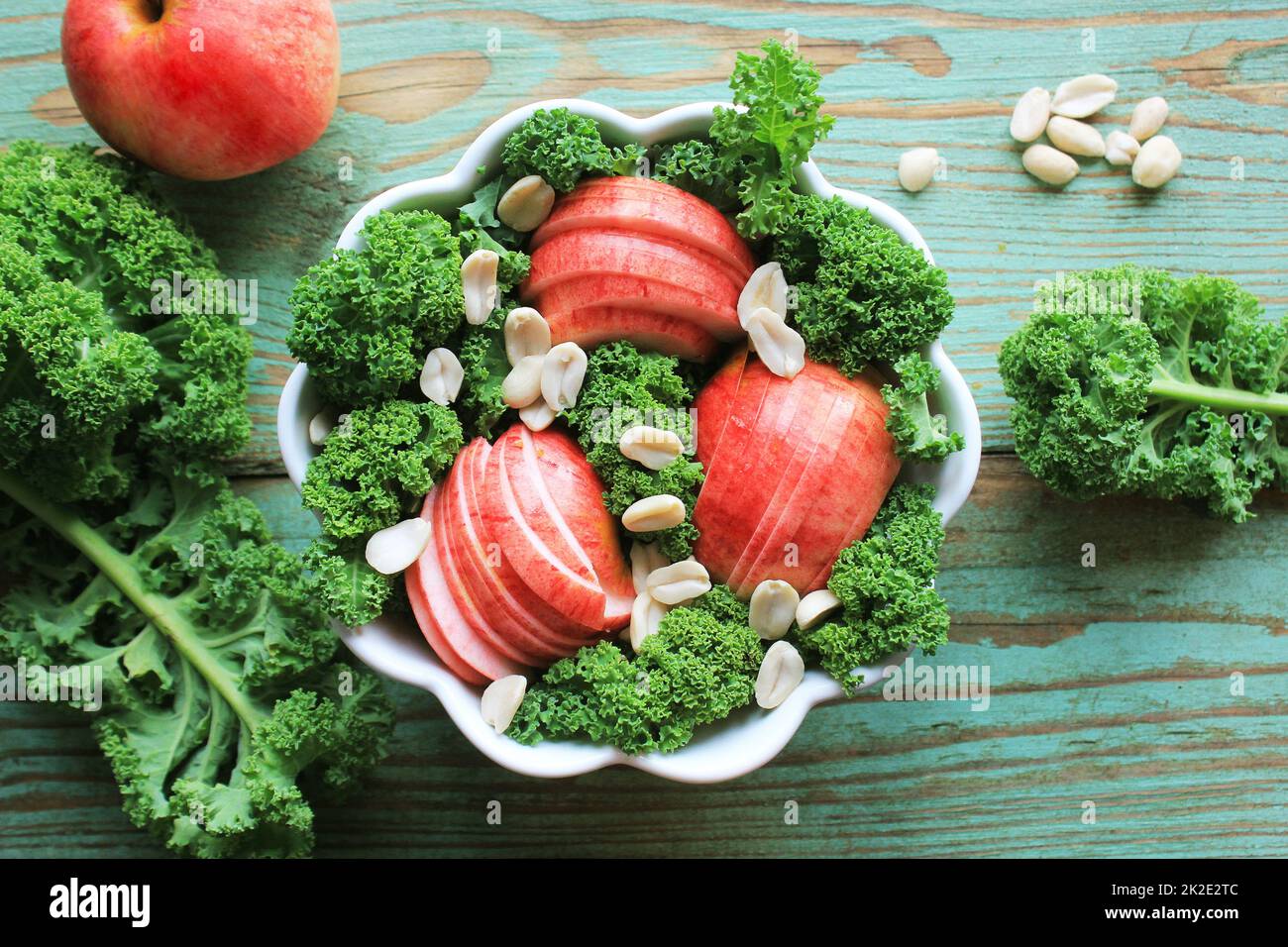 Salat mit Grünkohl Kopfsalat, Äpfeln, Erdnüsse. Ansicht von oben Stockfoto