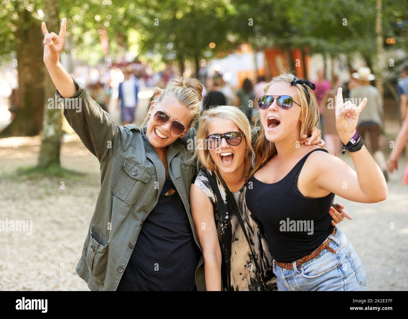 Hören Sie. Drei Freundinnen feiern bei einem Musikfestival im Freien. Stockfoto