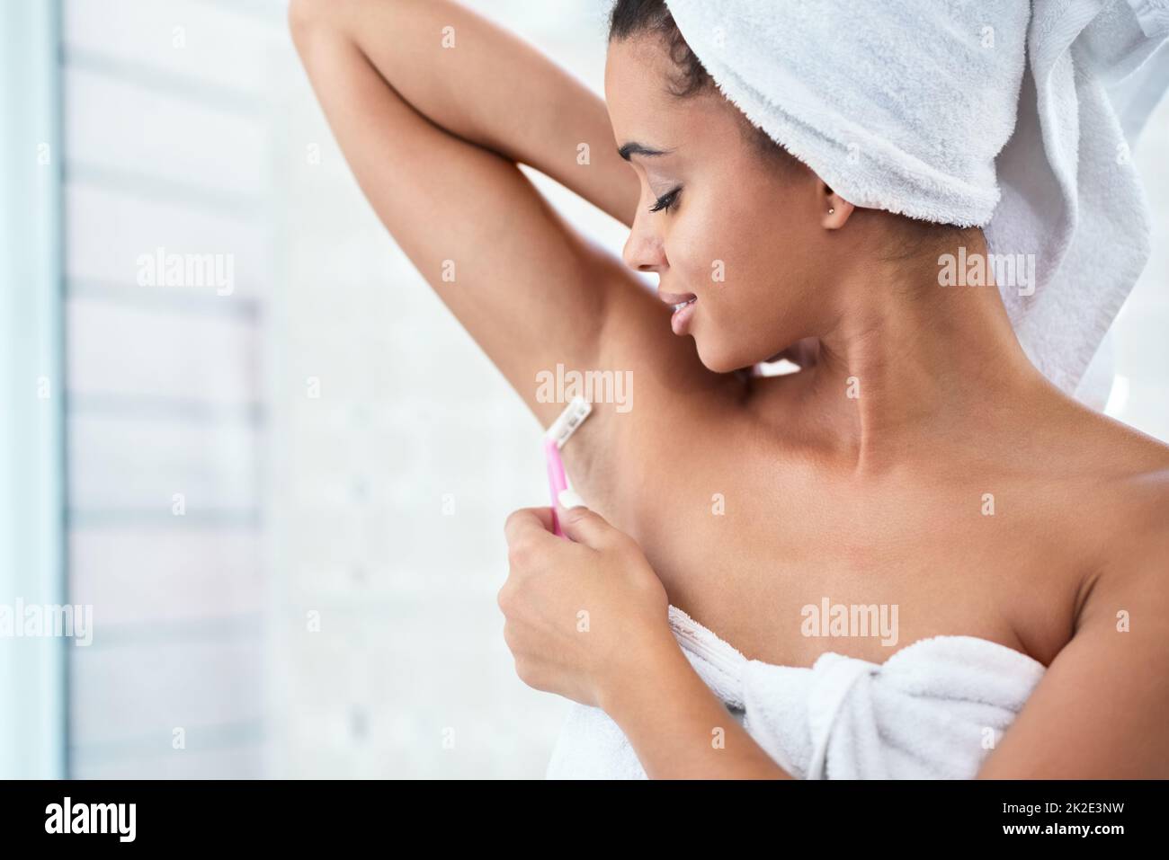 Eine gründliche Rasur. Aufnahme einer attraktiven jungen Frau, die ihre Achselhöhlen mit einem Rasiermesser im Badezimmer rasieren konnte. Stockfoto