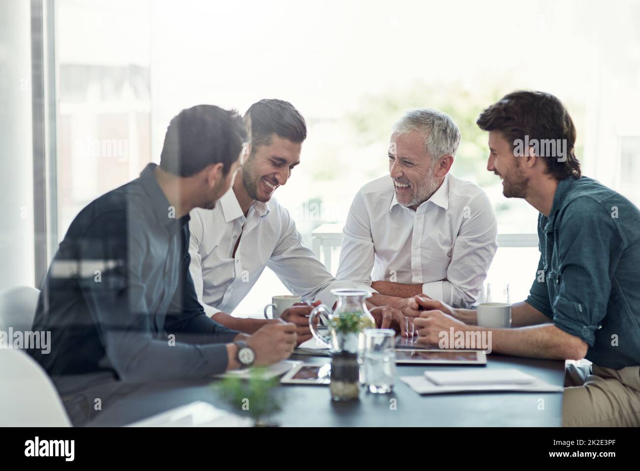 Dieser Sitzungssaal ist voller Positivität. Aufnahme einer Gruppe von Geschäftsleuten, die sich in einem Büro um einen Tisch treffen. Stockfoto