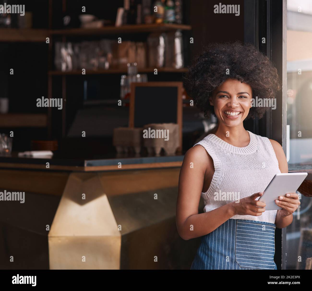 Wir aktualisieren nur unser Online-Menü. Porträt einer glücklichen jungen Geschäftsbesitzerin, die ihr Tablet benutzt, während sie in ihrem Café steht. Stockfoto