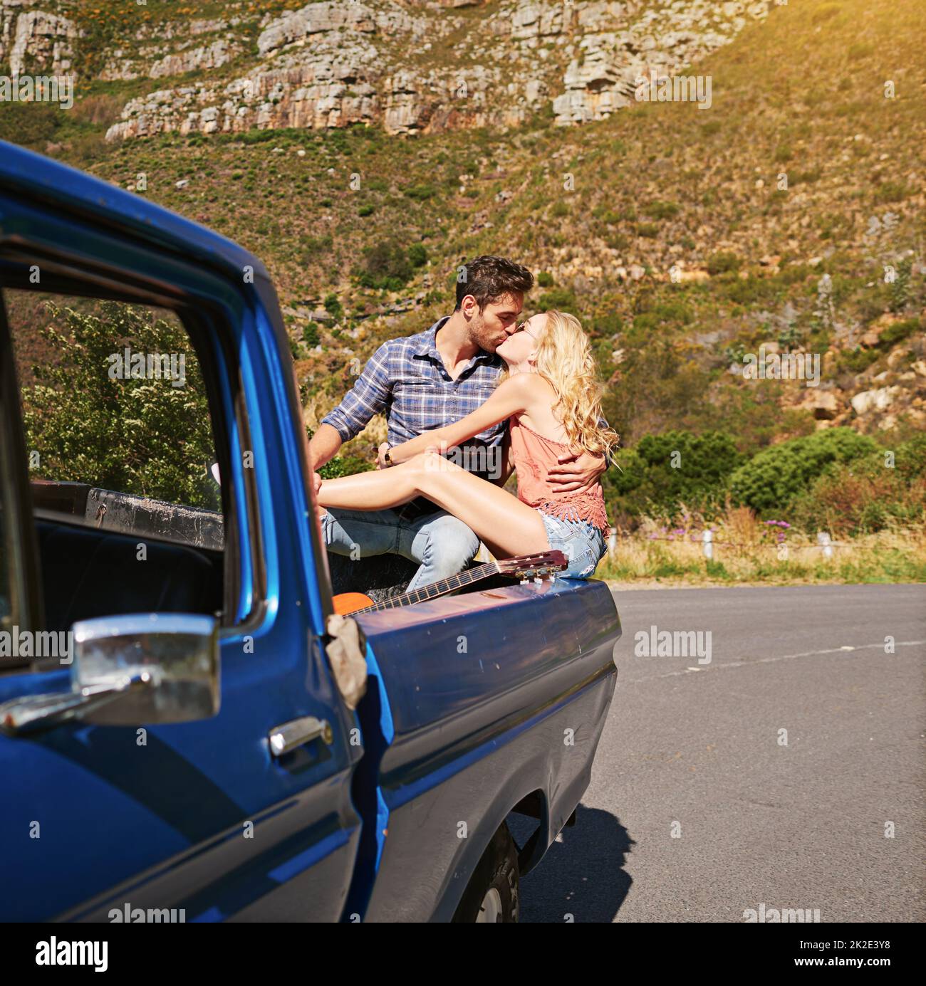 Reisen bringt Kraft und Liebe zurück in Ihr Leben. Aufnahme eines jungen Paares, das sich einen Kuss auf der Rückseite eines Pickup-Trucks teilt. Stockfoto