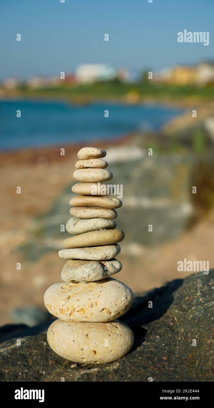 Balancierte Steinpyramide auf Sand am Strand. Stockfoto