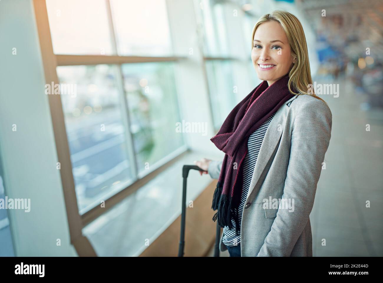 Lasst die Reise beginnen. Porträt einer jungen Frau, die mit ihrem Gepäck auf einem Flughafen steht. Stockfoto