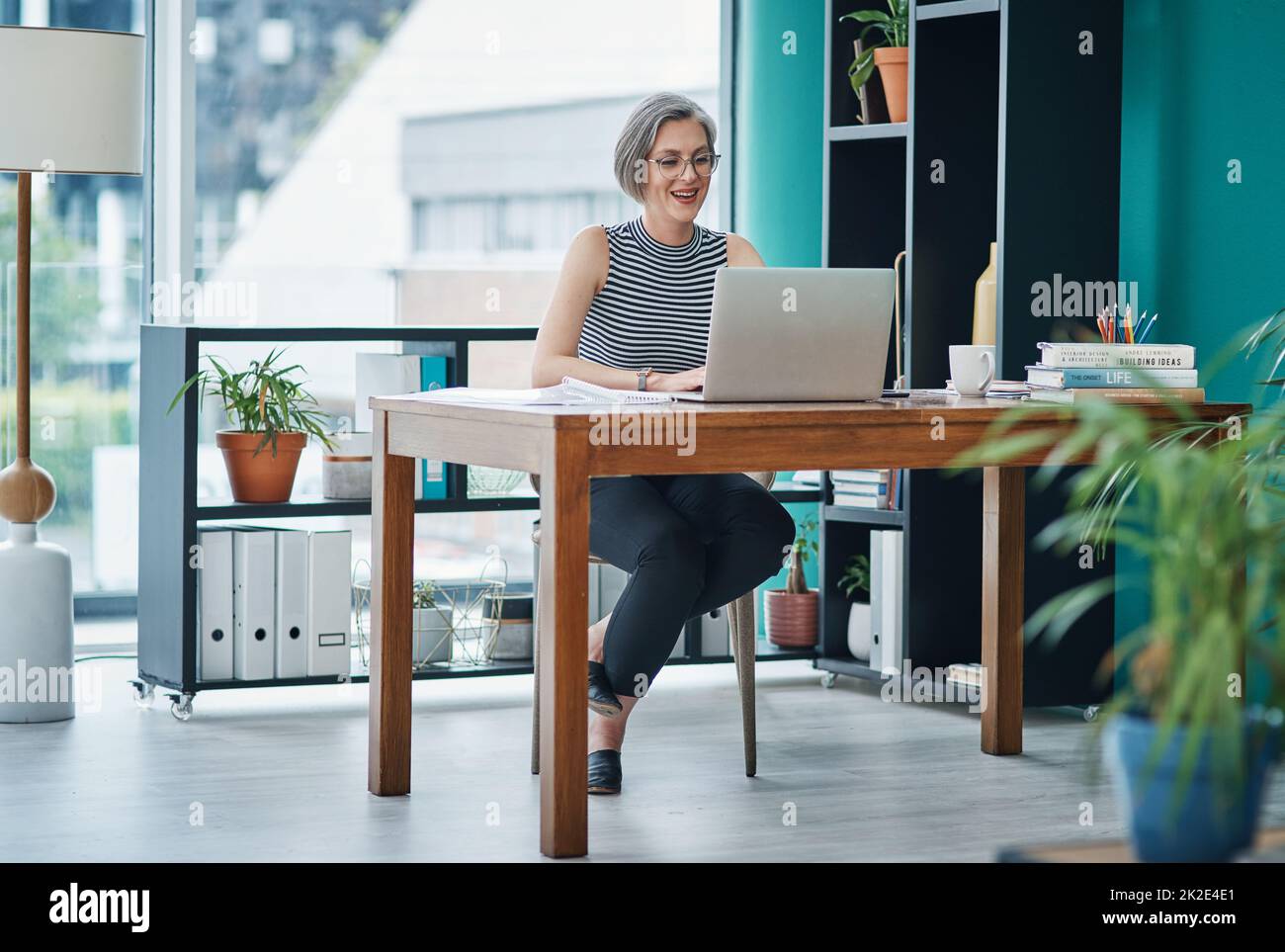 Nutzen Sie Online-Tools, um Ihre Effizienz und Produktivität zu steigern.  Aufnahme einer reifen Geschäftsfrau, die ihren Laptop benutzt, während sie  an ihrem Schreibtisch sitzt Stockfotografie - Alamy
