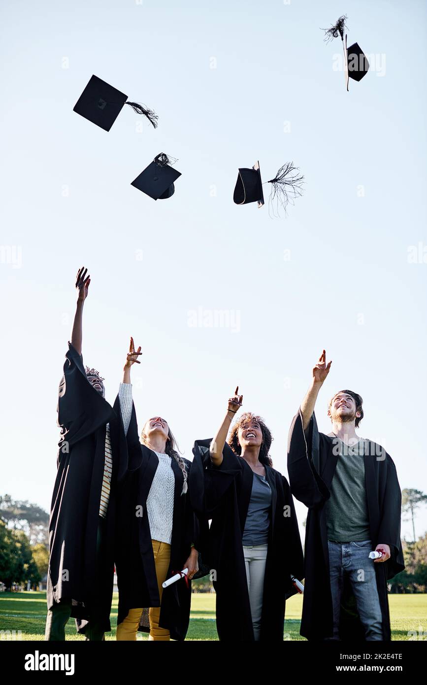 Die Belohnungen sind alle die Mühe wert. Aufnahme einer Gruppe von Studenten, die ihre Hüte am Tag der Abschlussfeier in die Luft warfen. Stockfoto