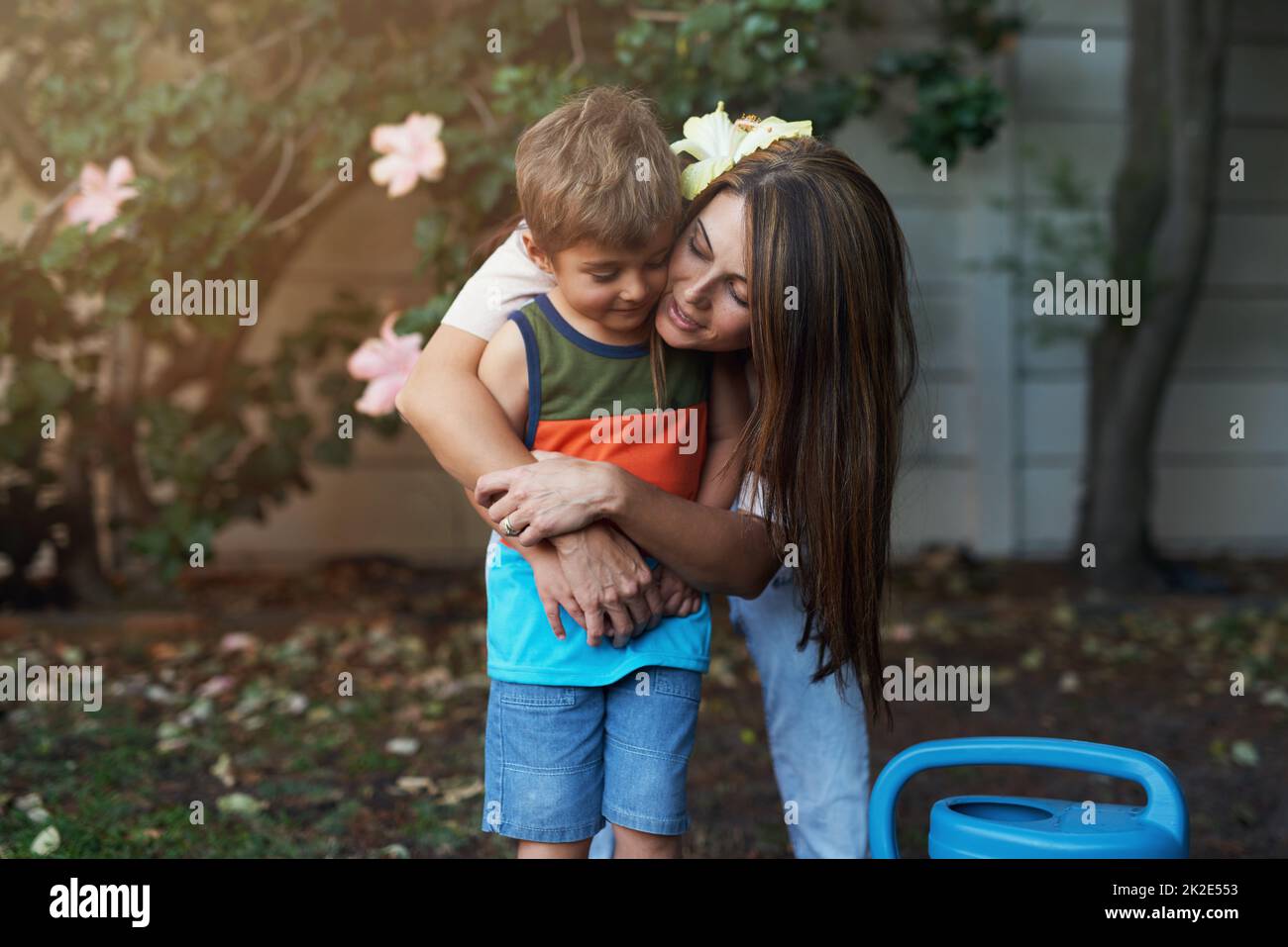 Sie liebt ihn zu Bits. Aufnahme einer Mutter, die ihren Sohn im Garten umarmt. Stockfoto