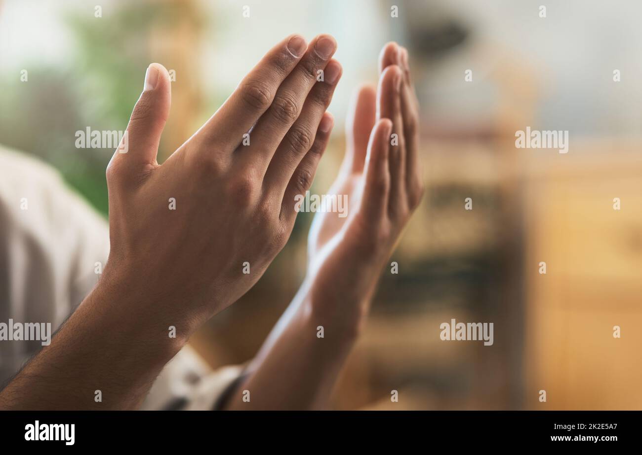 Gebt alles auf, was euch wiegt. Aufnahme eines nicht erkennbaren muslimischen Mannes, der zu Hause in der Lounge betet. Stockfoto