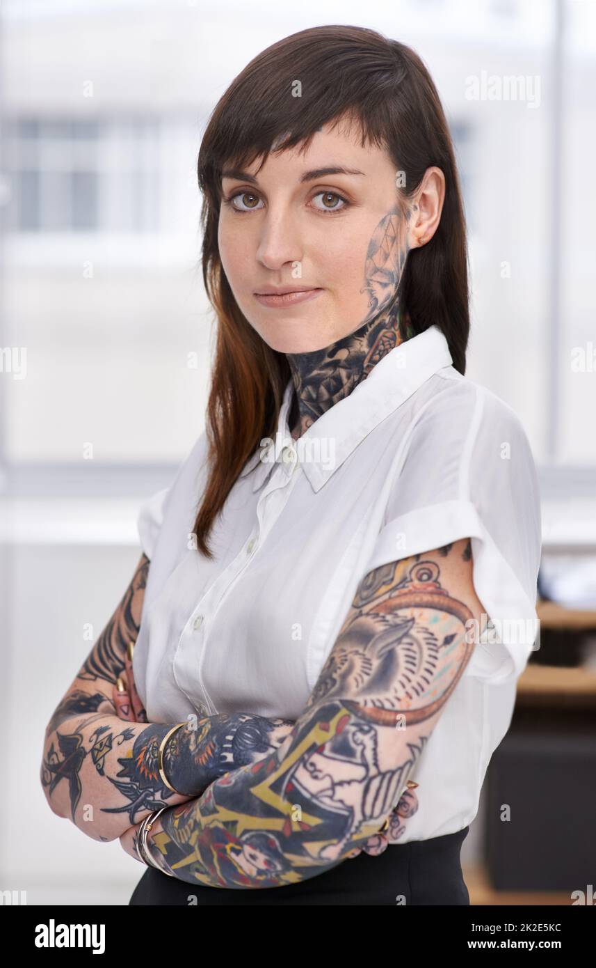 Shes bereit, die Unternehmensszene zu rocken. Eine mit Tätowierungen bedeckte junge Geschäftsfrau in ihrem Büro. Stockfoto