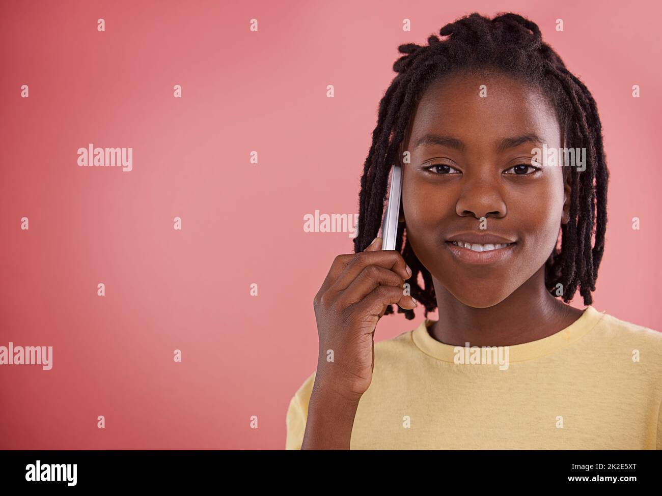 Ich will mal rumhängen. Studioportrait eines Jungen, der sein Mobiltelefon vor einem farbigen Hintergrund benutzt. Stockfoto