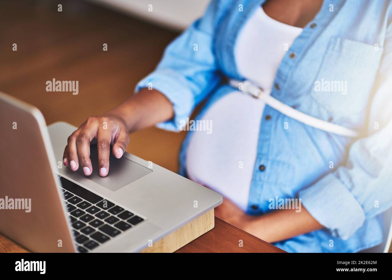 Online-Tipps für eine wachsende Schwangerschaft recherchieren. Kurzer Screenshot einer Schwangeren, die einen Laptop benutzt, während sie von zu Hause aus arbeitet. Stockfoto