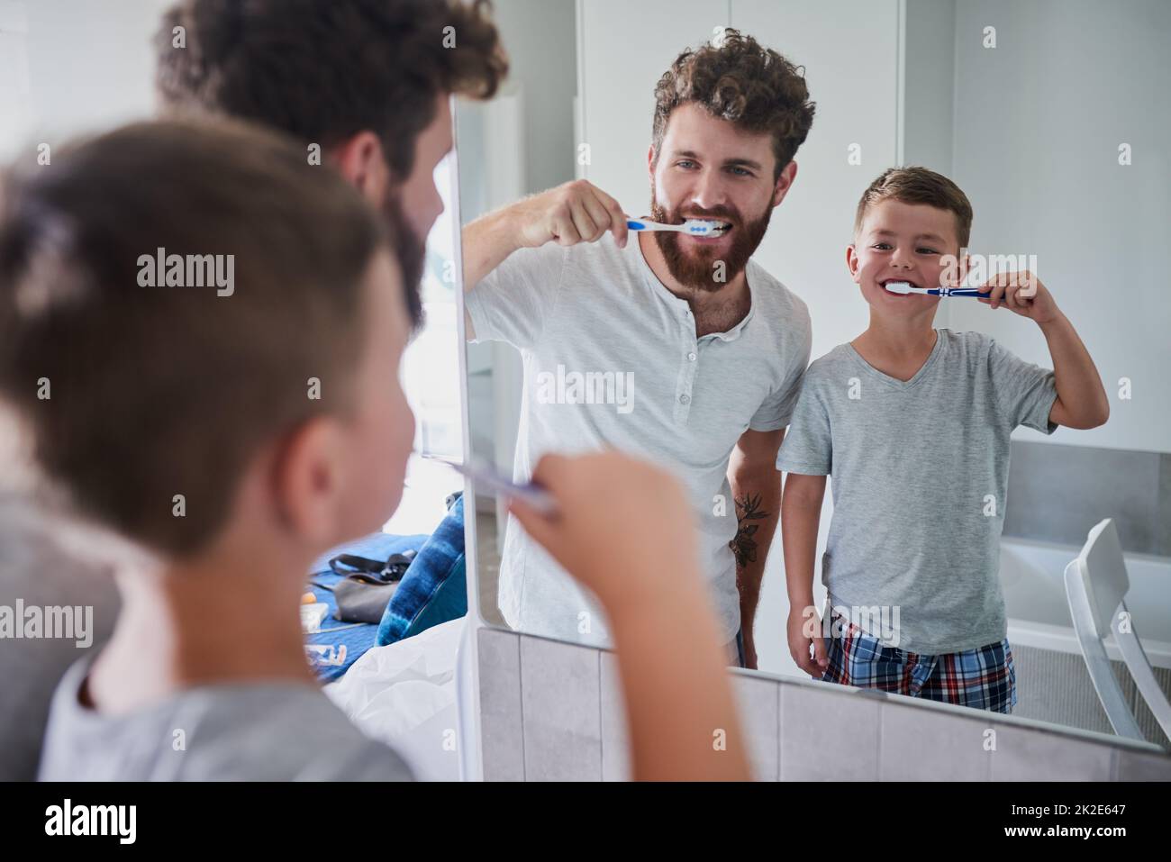 Beginnen Sie frühzeitig mit guten Mundgewohnheiten. Aufnahme eines Vaters und seines kleinen Sohnes, der sich im Badezimmer zu Hause die Zähne putzt. Stockfoto