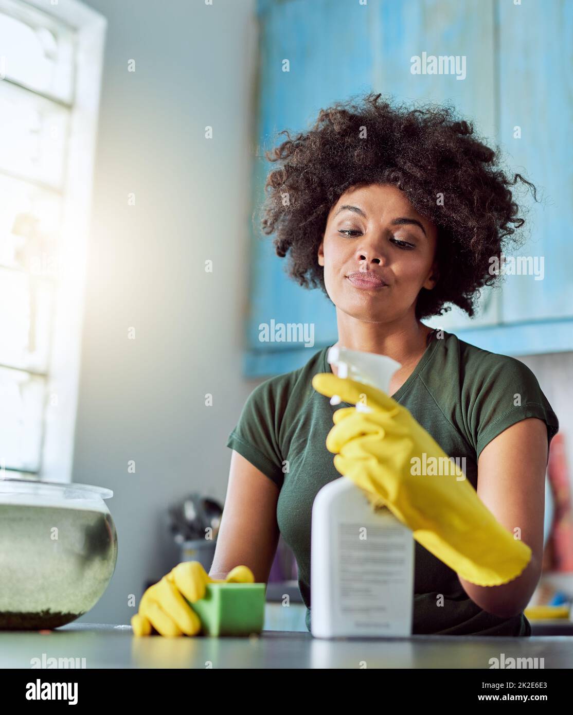 Frühjahrsputz. Kurzer Schuss einer attraktiven jungen Frau mit gelben Handschuhen, die ihr Zuhause putzt. Stockfoto
