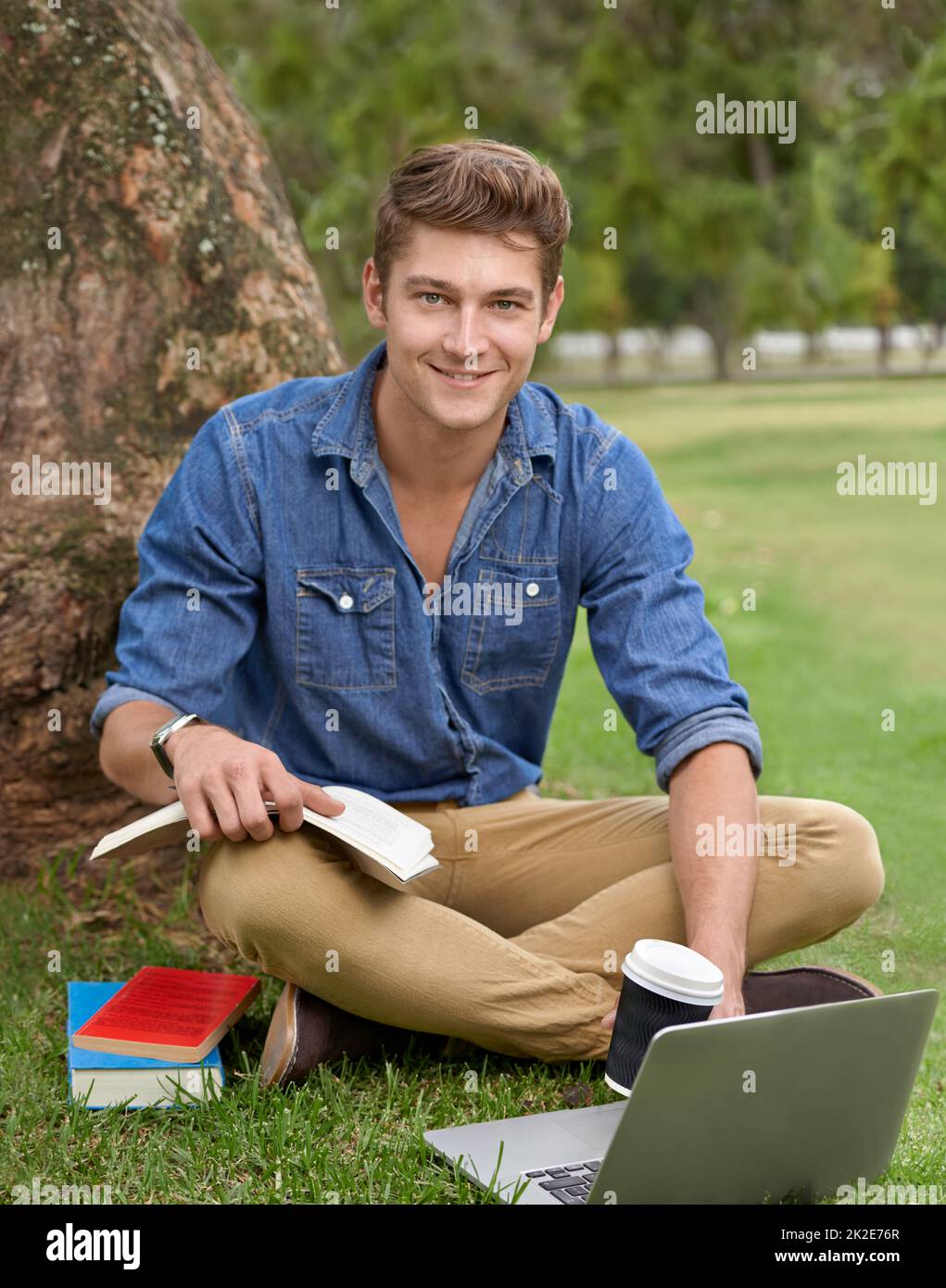 Das ist besser als die Bibliothek. Porträt eines hübschen jungen Mannes, der mit einem Laptop im Park studiert. Stockfoto