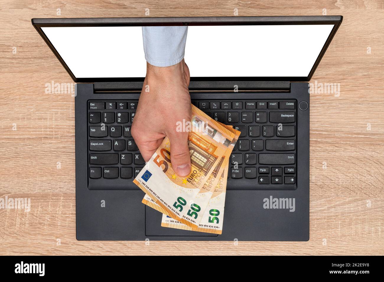 Geben oder Nehmen von Geld über einen Laptop-Bildschirm Stockfoto