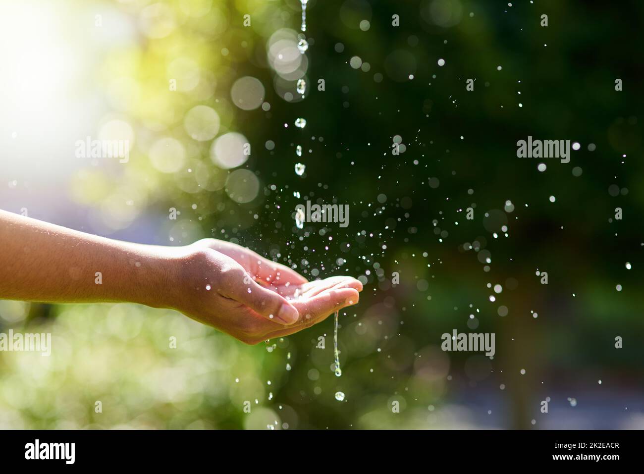 Wasser ist Leben. Ein Handschuss wurde ausgestreut, um draußen einen Wasserstrom zu fangen. Stockfoto