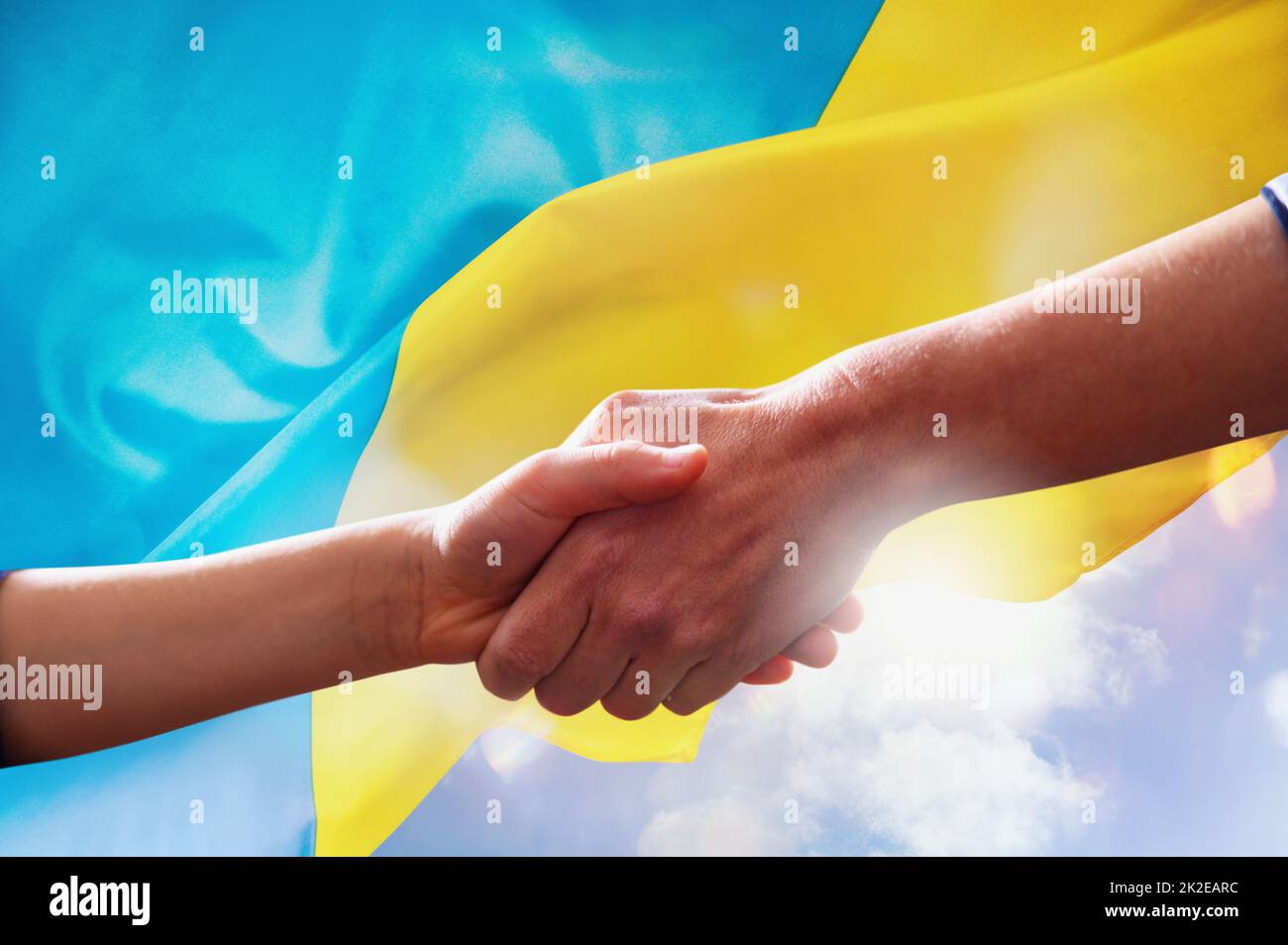 Sonnige ukrainische Landesflagge mit helfenden Händen als Unterstützung Stockfoto