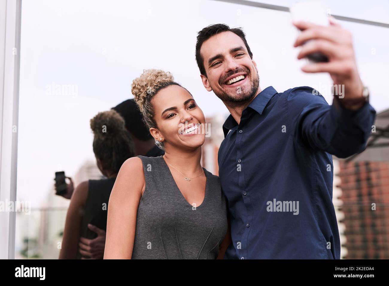 Welt, werden Sie bald unseren Erfolg sehen. Aufnahme von zwei Kollegen, die vor einem Büro zusammen ein Selfie machen. Stockfoto