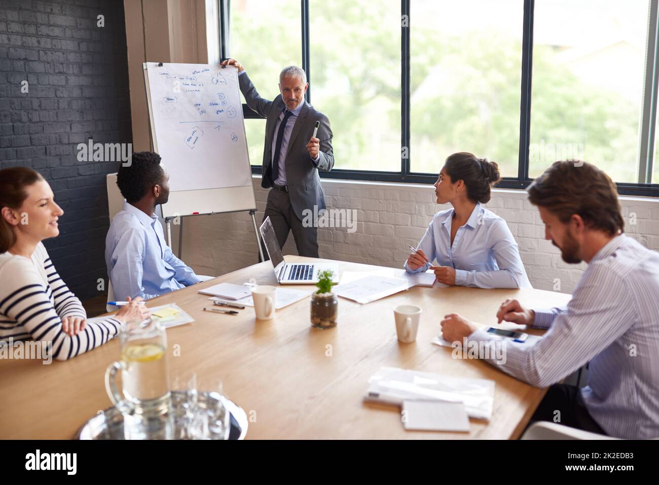 Sie auf den Weg bringen. Ich habe einen reifen Geschäftsmann gedreht, der eine Präsentation im Sitzungssaal gegeben hat. Stockfoto