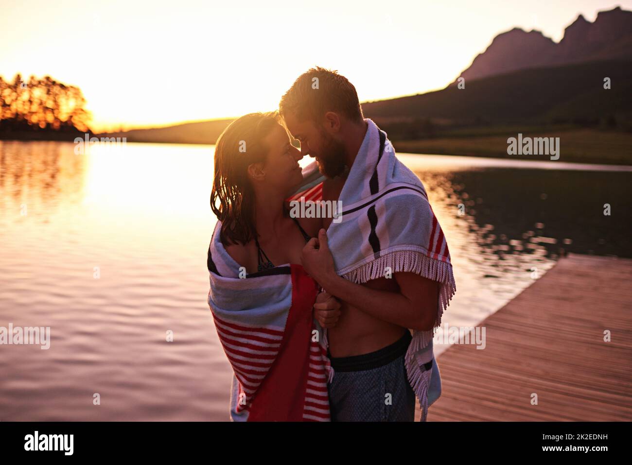 Nur wir beide Aufnahme eines anhänglichen jungen Paares in Badeanzügen in einem Handtuch an einem See. Stockfoto