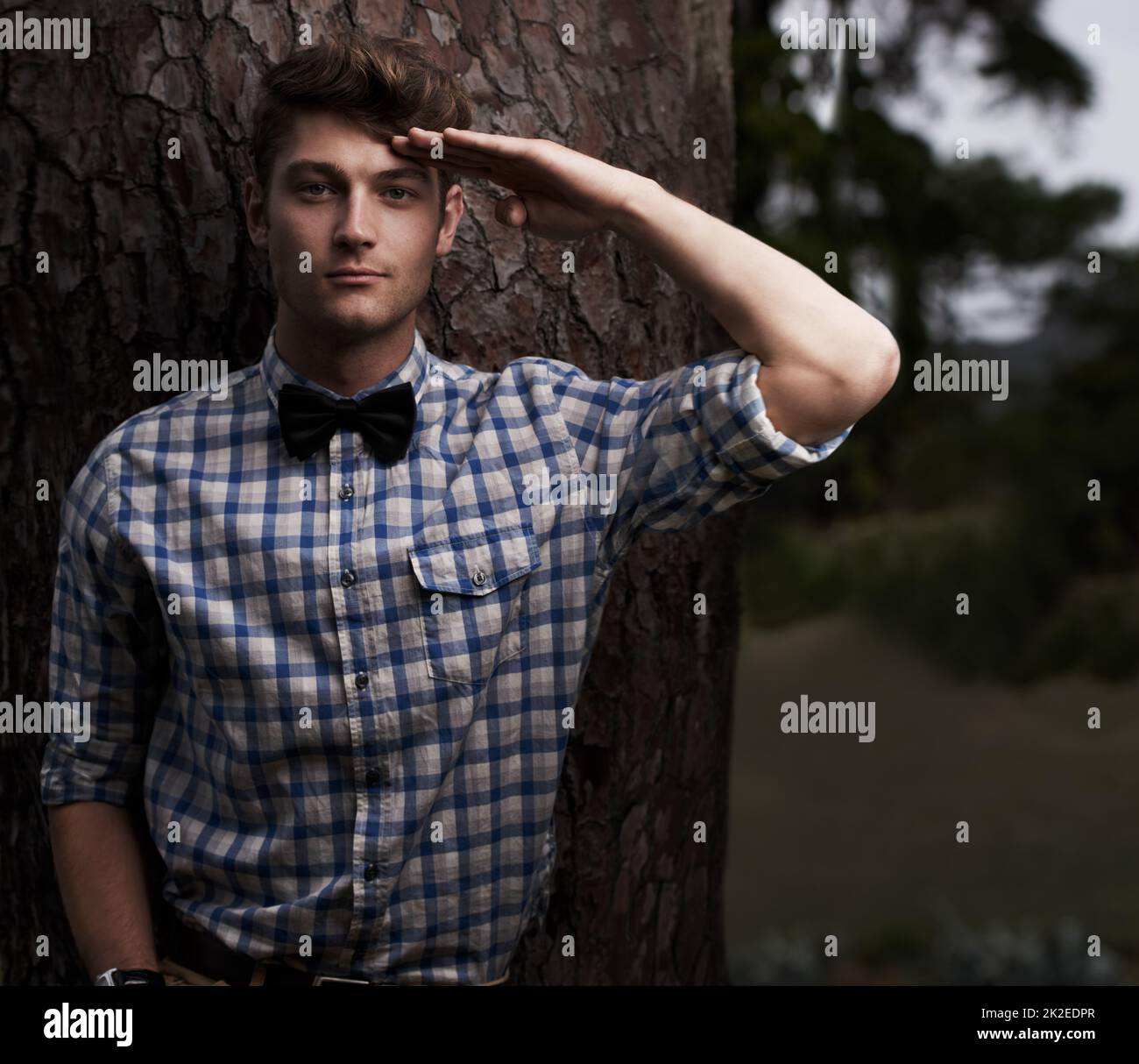 Heres to You. Porträt eines hübschen jungen Mannes, der die Kamera grüßelt, während er draußen vor einem Baum steht. Stockfoto