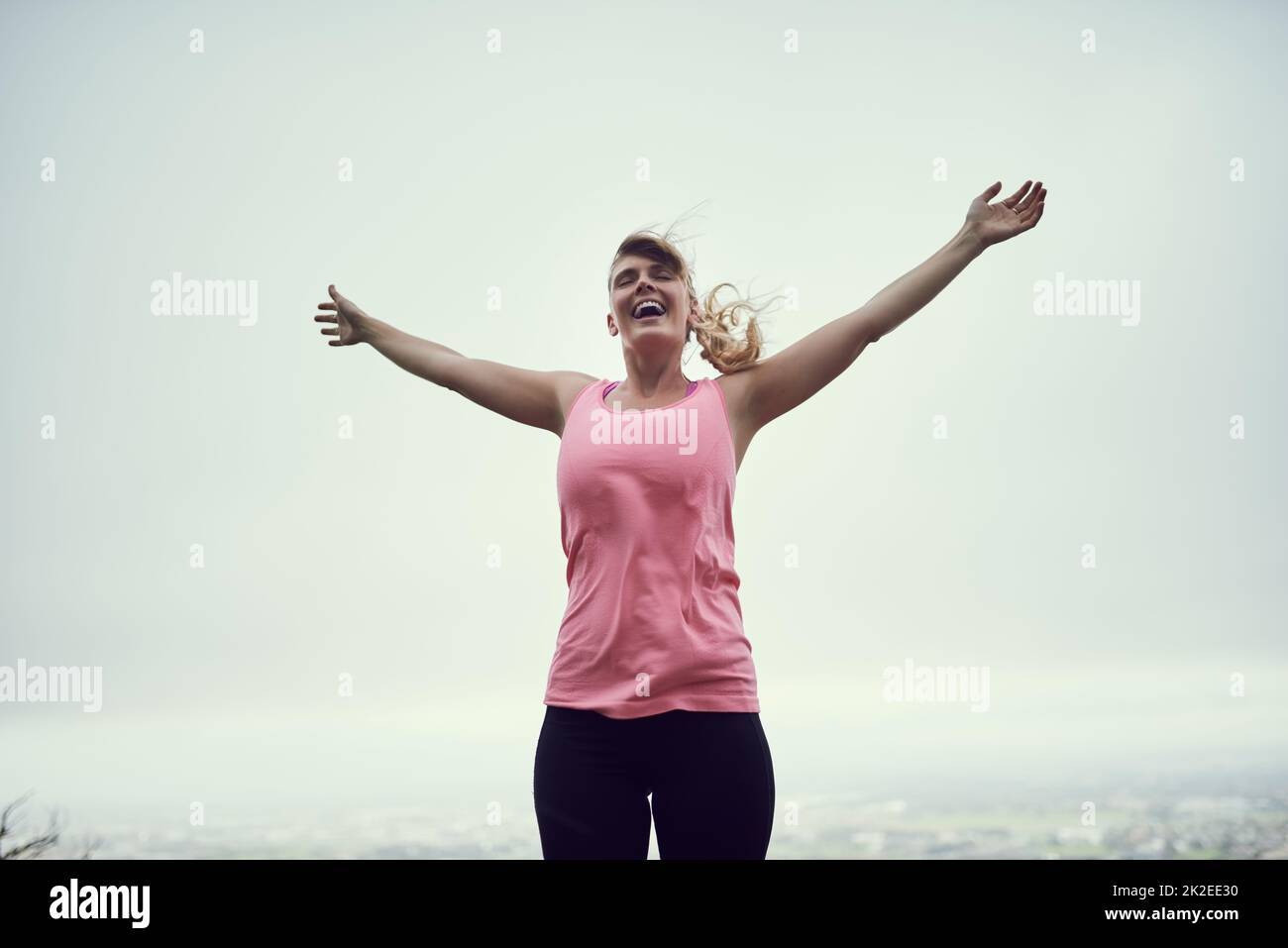 Sich fit und frei fühlen. Aufnahme einer glücklichen jungen Frau, die sich während eines Laufs in der Stadt frei fühlt. Stockfoto