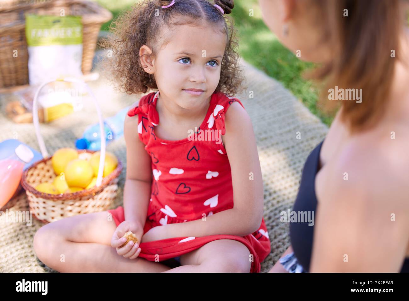 Mama kann einfach nicht nein sagen, wenn ich dieses Gesicht mache. Aufnahme eines entzückenden kleinen Mädchens bei einem Picknick im Park mit ihrer Mutter. Stockfoto