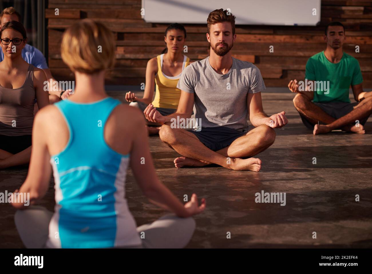 Yoga ist die Wissenschaft im Hier und Jetzt. Aufnahme einer Yogalehrerin, die ihre Klasse anweist. Stockfoto